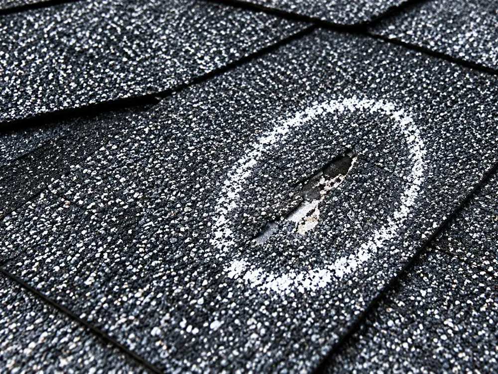 Hail bruising marked on a shingle during a roof assessment in Eden Prairie, MN Hail bruising marked on a shingle during a roof assessment in Eden Prairie, MN
